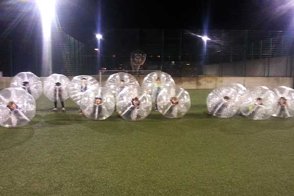 Kids in bubble footballs at a party