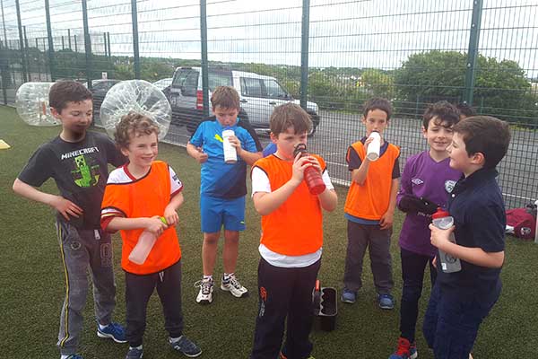 Groups of young boys having a drink between halves of a soccer game.