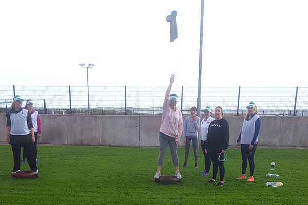 Group ladies on Hen Party playing a game involving throwing a wellington.