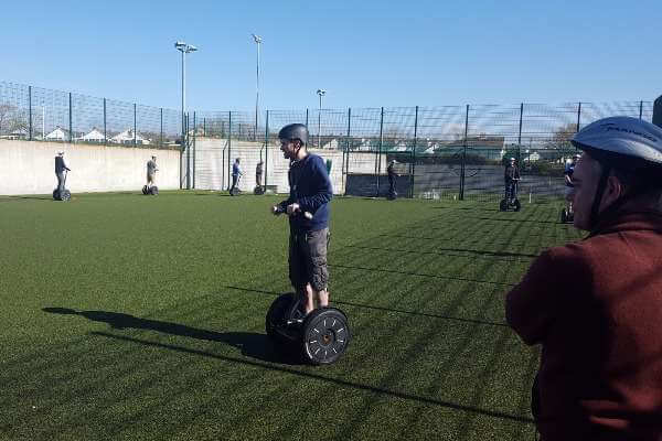 Segways driving around on astroturf surface.